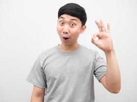 homem asiático camisa cinza alegre mão ok fundo branco foto