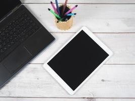 espaço de trabalho na mesa, caixa de caneta para laptop e vista superior do tablet foto