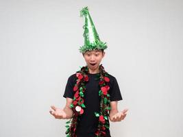 jovem asiático camisa preta com chapéu verde e borla colorida alegre no rosto mão para cima e olhar para baixo na mão dizer uau no fundo branco isolado