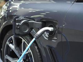 plugue do veículo de carregamento elétrico na bateria de recarga no carro de cor preta energia limpa para o conceito futuro foto