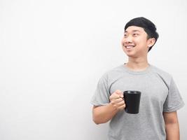 homem segurando a xícara de café sorrindo e olhando para o espaço da cópia foto