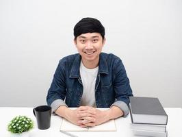 homem sente-se à mesa do espaço de trabalho sorrindo retrato fundo branco foto