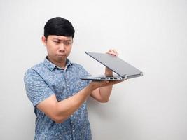 camisa azul homem asiático laptop meio aberto na mão gesto espionando e sentindo medo conteúdo foto