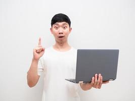 homem asiático, segurando laptop, dedo apontado para cima, tenha ideia, cara feliz, fundo branco foto