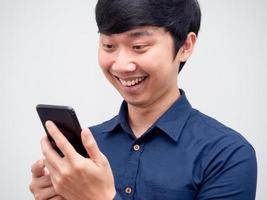 homem asiático alegre usando telefone celular na mão retrato de rosto feliz foto
