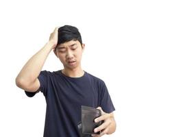 homem asiático se sentindo triste e tenso com dinheiro na mão toca sua cabeça com a mão fundo branco isolado foto
