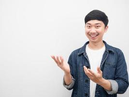 homem asiático camisa jeans gesto sorridente apontando a mão para o espaço da cópia foto
