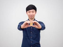 homem asiático alegre mostra a mão segurando bitcoin de ouro no fundo branco foto