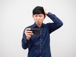 homem asiático jogando no celular sentindo-se entediado toque em sua cabeça fundo branco foto