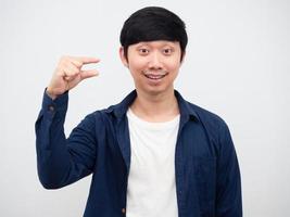 homem asiático mostra dedos de tamanho pequeno no retrato de fundo branco, homem alegre mostra dedo mindinho