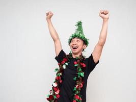 jovem feliz e alegre mostra braços e punho com chapéu verde e borla colorida em branco isolado feliz ano novo celebração do conceito foto