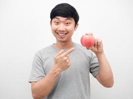 homem sorrindo e apontando para maçã vermelha na mão retrato foto