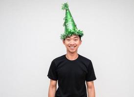 jovem asiático camisa preta com chapéu verde sorriso feliz e olhar alegre para a câmera no branco isolar o conceito de feliz ano novo foto