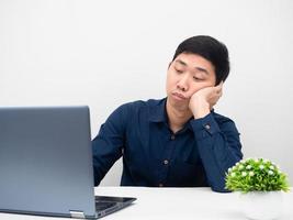 homem trabalha em casa usando laptop sentindo-se tentado e quer dormir foto