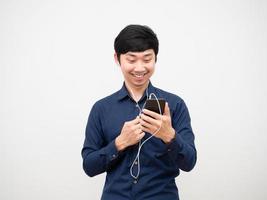 homem asiático se sentindo feliz ouvindo música com fone de ouvido rosto sorriso fundo branco foto