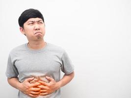 homem camisa cinza gesto dor de estômago sentindo-se infeliz olhando para o espaço da cópia foto