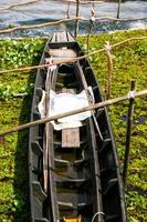 velho pescador de barco de madeira no lago sul da tailândia e viagens foto