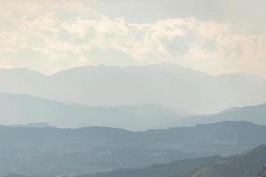 vista aérea de montanhas enevoadas em camadas de montanhas com sol, ambiente natural foto