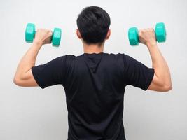 homem segurando drumbbell para suporte de treino voltar foto