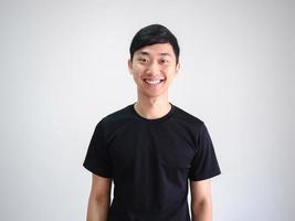 jovem tailandês camisa preta alegre com sorriso feliz olhar para a câmera cortar meio retrato do corpo no branco isolado foto