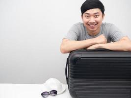 homem asiático alegre sorrindo com espaço de cópia de bagagem foto