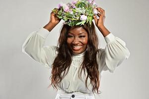 retrato de uma jovem mulher afro-americana, modelo de moda, com grandes flores no cabelo foto