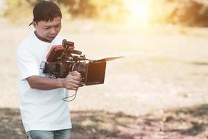 os diretores de fotografia asiáticos operam a filmagem cinematográfica da câmera e o criador de conteúdo usa a filmagem da câmera foto