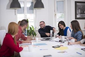 mulher de negócios explicando assuntos de negócios para sua equipe em uma sala de reuniões foto