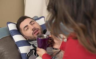 jovem mulher consolando seu marido doente foto