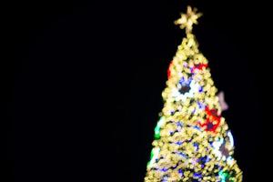 árvore de natal embaçada e decorações e luzes foto