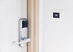 porta de entrada em madeira com sistema de fechadura eletrônica e botão de campainha foto