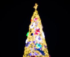 árvore de natal embaçada e decorações e luzes foto