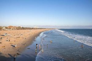 vista aérea de pessoas curtindo na praia de veneza e ondas espirrando no mar foto