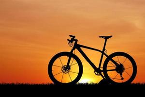 silhueta de uma bicicleta no pôr do sol foto