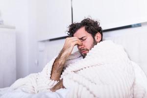 pessoas, conceito de hora de dormir e descanso - homem deitado na cama em casa sofrendo de dor de cabeça ou ressaca, doença, conceito de problema de vírus sazonal. foto