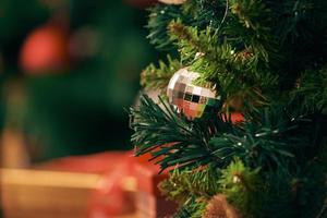 decorando a árvore de natal no fundo brilhante foto