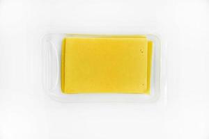fatias finas de queijo em um suporte de plástico. delicioso queijo amarelo picado. queijo em um pacote da loja. foto