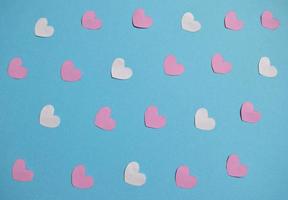 corações brancos, rosa e vermelhos sobre um fundo azul. padrão de corações do dia dos namorados. cartão de dia dos namorados com corações de cor branca foto