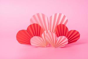 corações de papel em fundo rosa. composição minimalista de natureza morta para o dia dos namorados foto