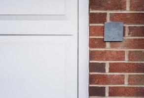 placa de ardósia cinza em uma parede de pedra para a indicação do número da casa, placa vazia pendurada no fundo da parede de tijolos ou bloco de concreto marrom para substituir o número do endereço da casa foto