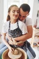 com o namorado ou marido. jovem ceramista feminina dentro de casa com produto de argila artesanal. concepção de cerâmica foto