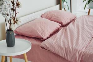 cama de cor rosa. interior e design do lindo quarto moderno durante o dia