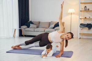 mulher fazendo exercícios. mãe com sua filha está em casa juntos foto