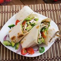 wraps de tortilha fresca com frango e legumes frescos no prato foto