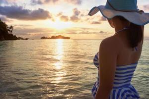 menina na praia ao nascer do sol foto