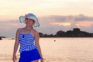 menina na praia ao nascer do sol sobre o mar foto