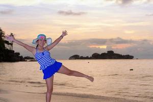 menina na praia ao nascer do sol sobre o mar foto