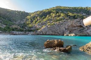 águas azul-turquesa em es portitxol, ibiza, espanha. baía escondida na ilha de ibiza, em sant joan de labritja. foto