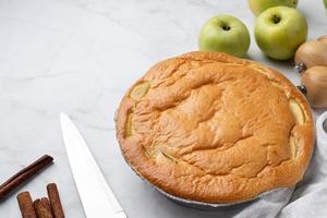 torta de maçã charlotte na mesa de concreto com maçã fresca e canela foto