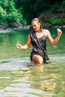 linda mulher de vestido preto em um rio foto